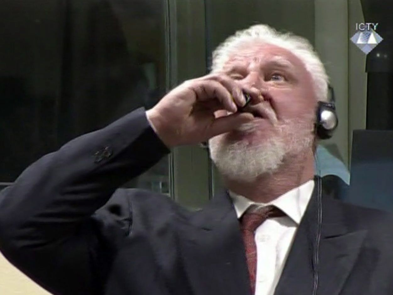 Der Angeklagte Slobodan Praljak nimmt einen Schluck aus einer kleinen Flasche.