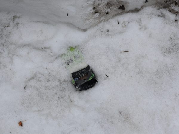Eine Packung Drehpapier für Joints liegt im Schnee. Der Platz ist bei Kiffern offenbar bekannt.