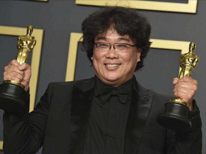 Bong Joon-ho mit den Goldstatuen links und rechts in der Hand