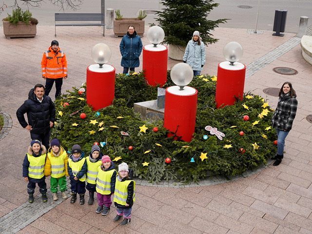 Rund um den Brunnen vor dem Harder Rathaus wurde ein Adventskranz gebastelt.