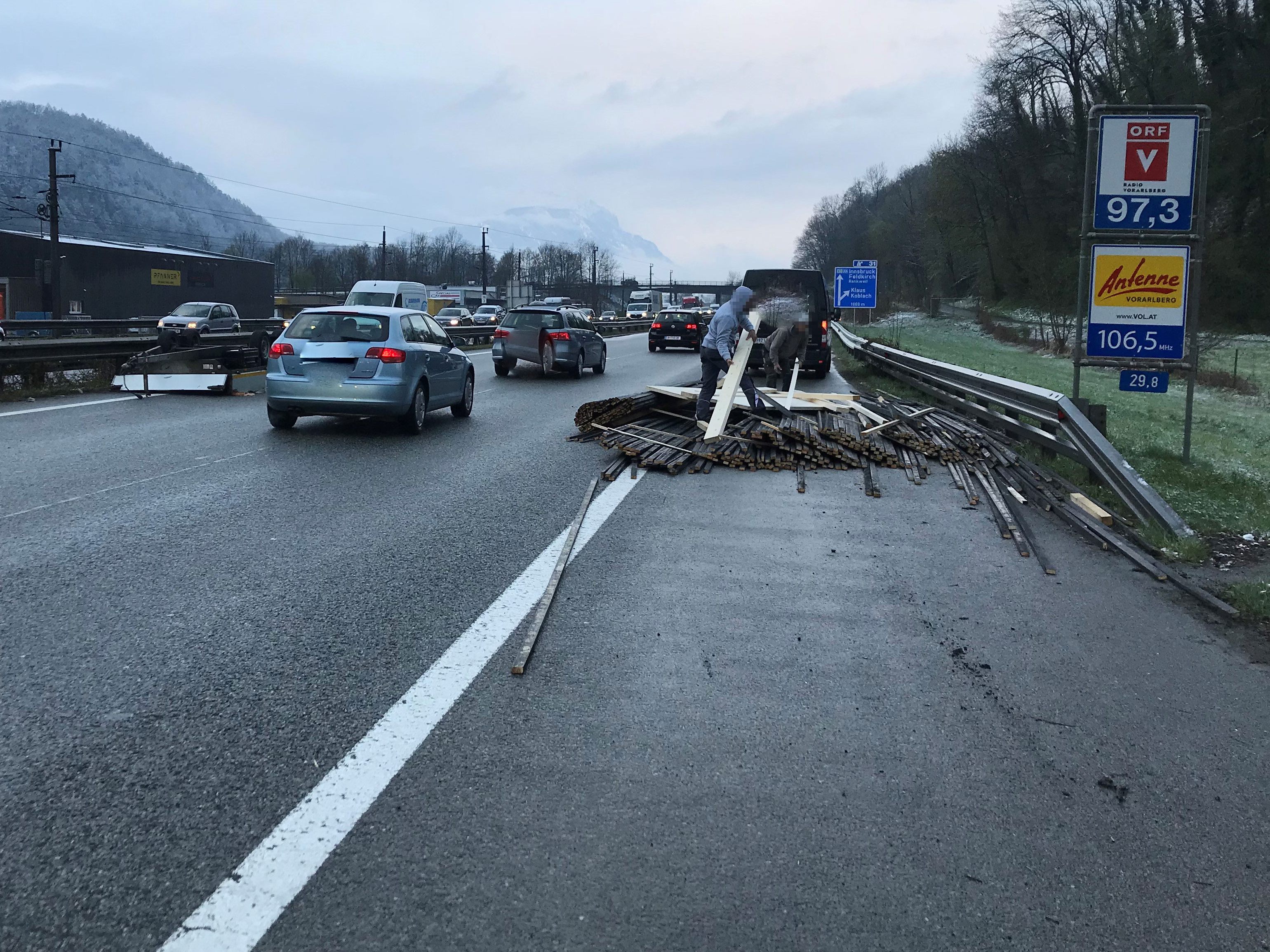Gekippter Anhänger verteilte Holzladung quer über die Fahrbahn.