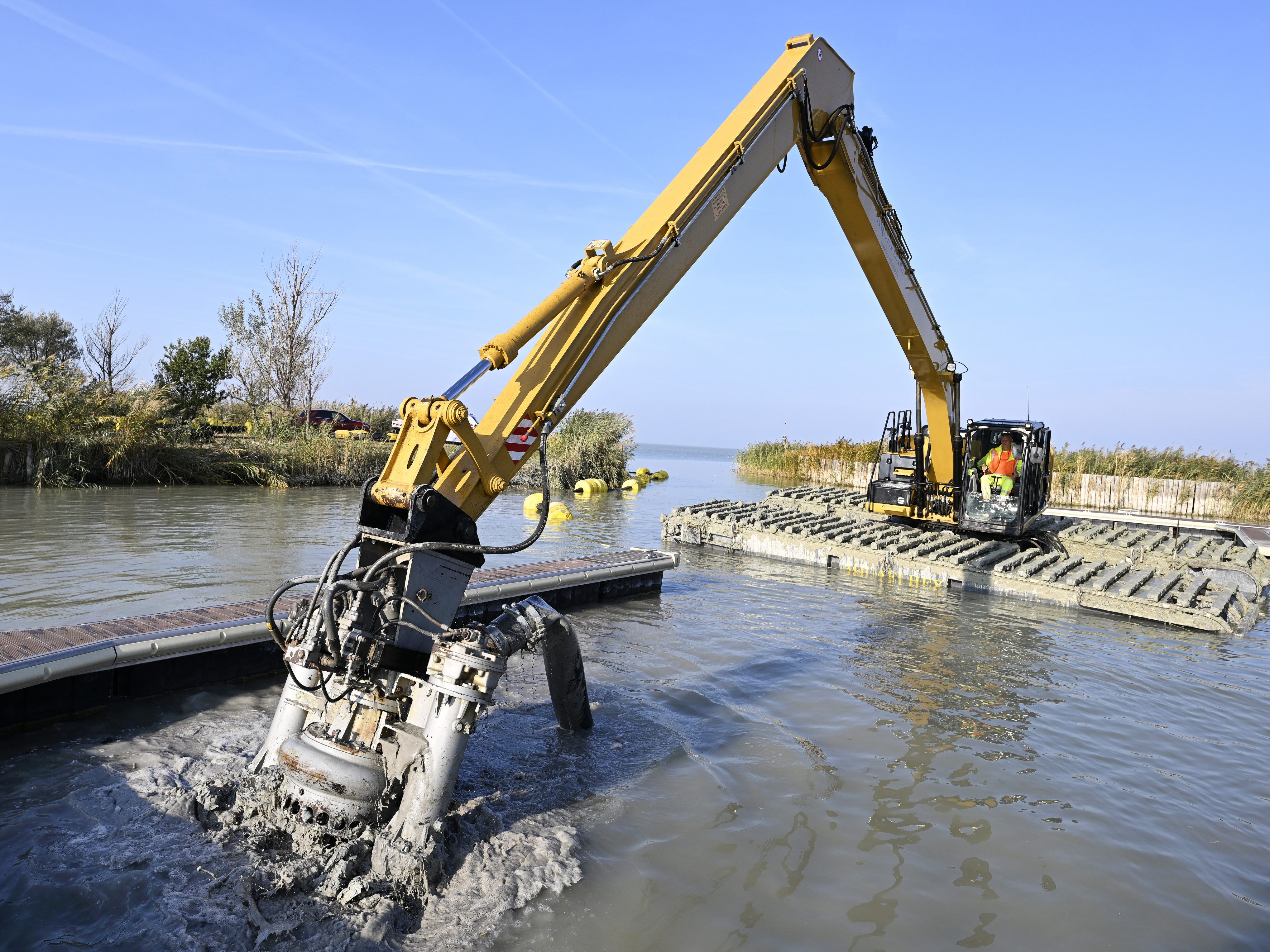 Ein Amphibienbagger saugt Schlamm aus den Häfen am Neusiedler See.