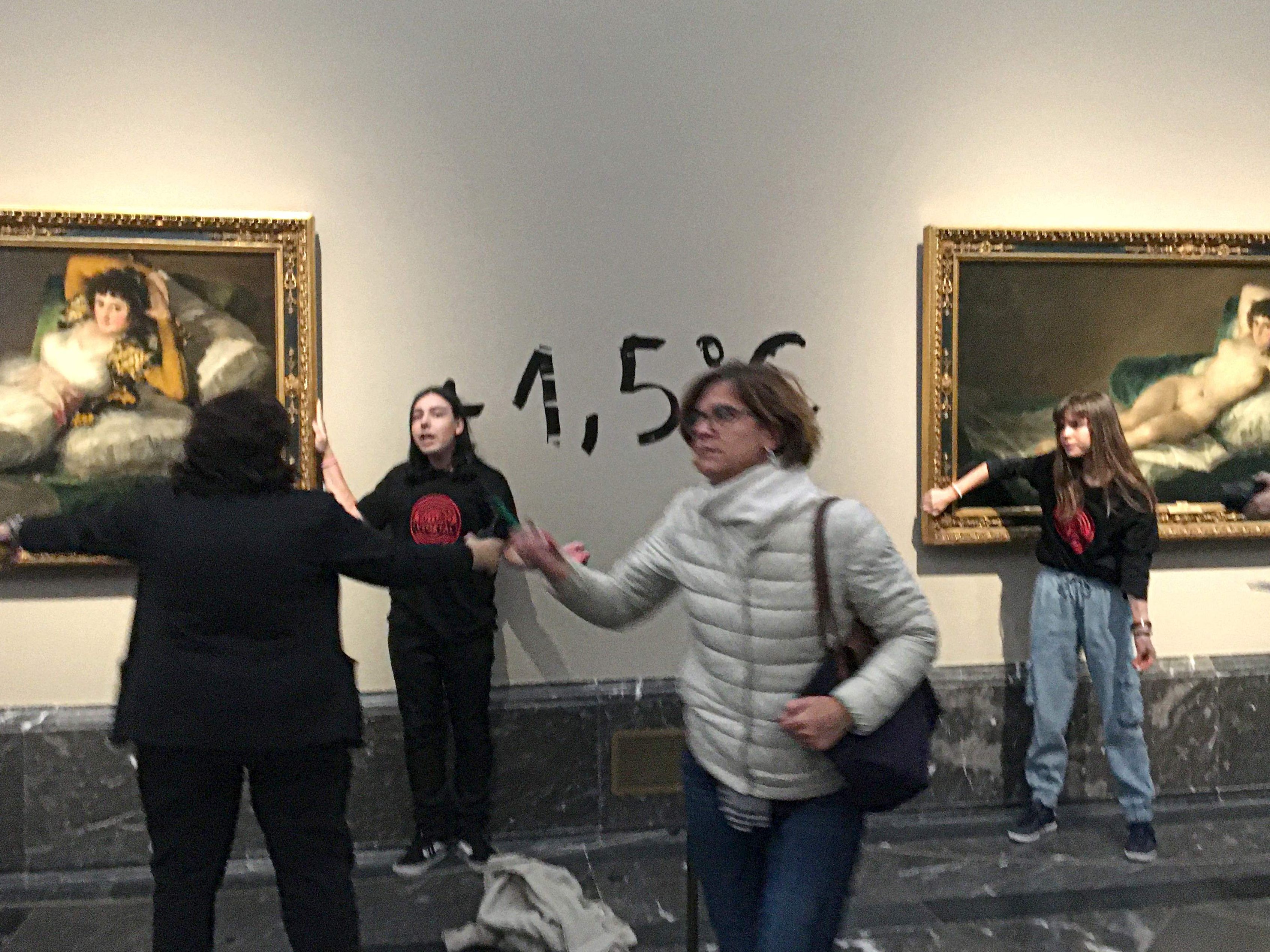 Klima-Aktivistinnen klebten sich an die Rahmen zweier Goya-Gemälde in Madrid und schrieben auf die Wand dazwischen "1,5"-Grad.