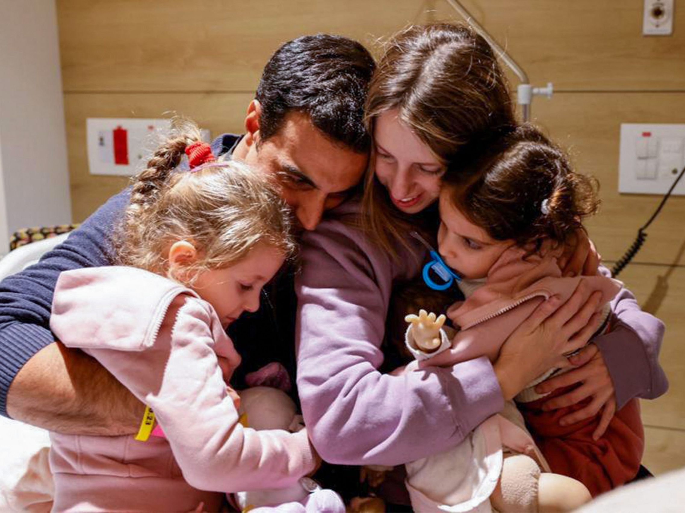 Das Bild zeigt Yoni Asher, der mit seinen Kindern Aviv, 2,5 Jahre alt, ihrer Schwester Raz, 4,5 Jahre alt, und seiner Frau Doron wiedervereint wird, einen Tag nachdem sie im Rahmen eines Geisel-Gefangenen-Austauschabkommens von der Hamas freigelassen wurden.