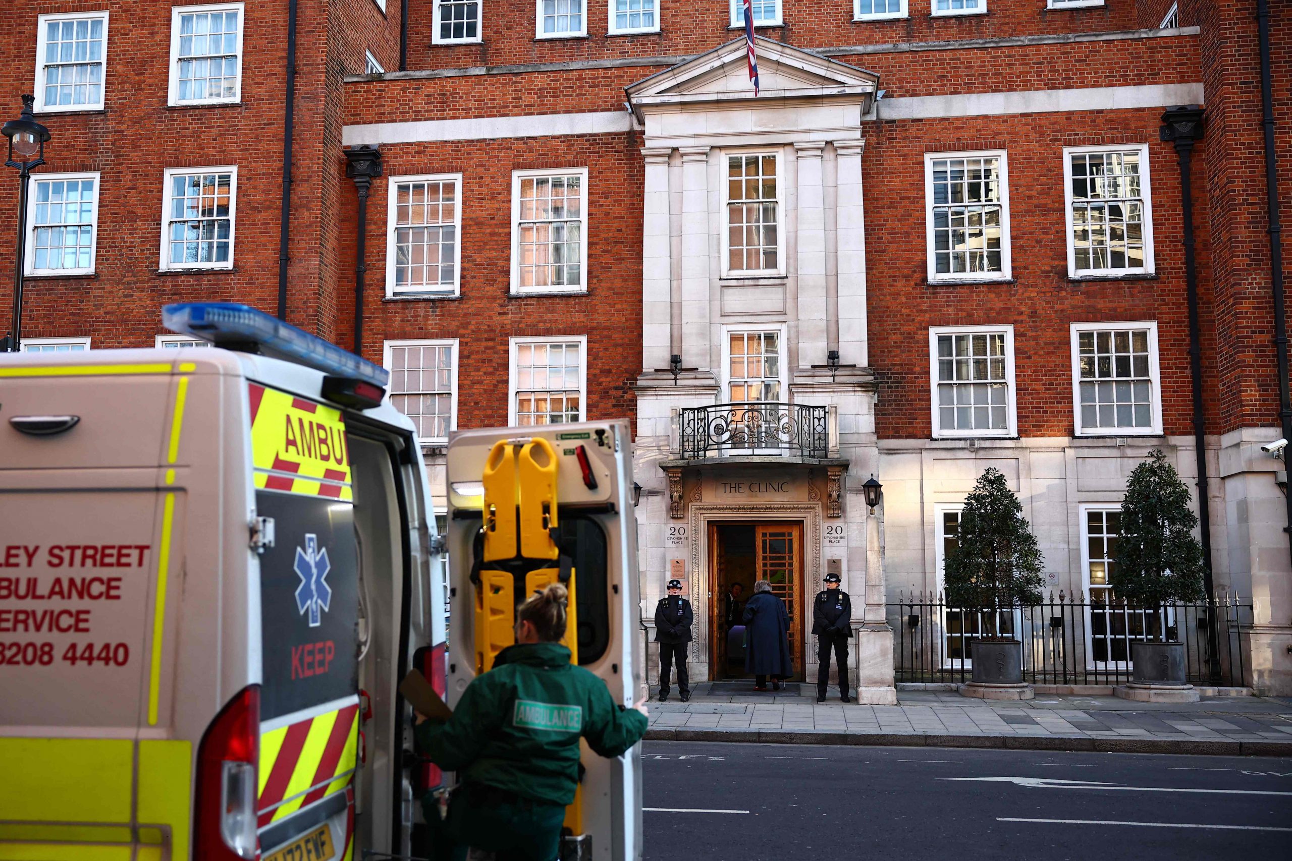 Ein Sanitäter öffnet die Hintertür eines Krankenwagens, während Polizisten am 18. Januar 2024 vor der London Clinic in London Wache stehen, wo die britische Prinzessin Catherine von Wales operiert wurde.