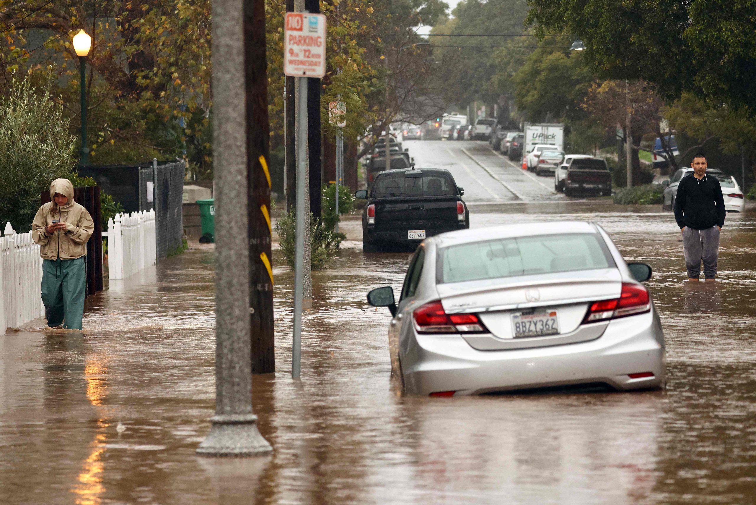 Menschen versammeln sich entlang einer überfluteten Straße, als am 4. Februar 2024 in Santa Barbara, Kalifornien, ein mächtiger, langanhaltender atmosphärischer Flusssturm, der zweite in weniger als einer Woche, über Kalifornien hereinbricht. 