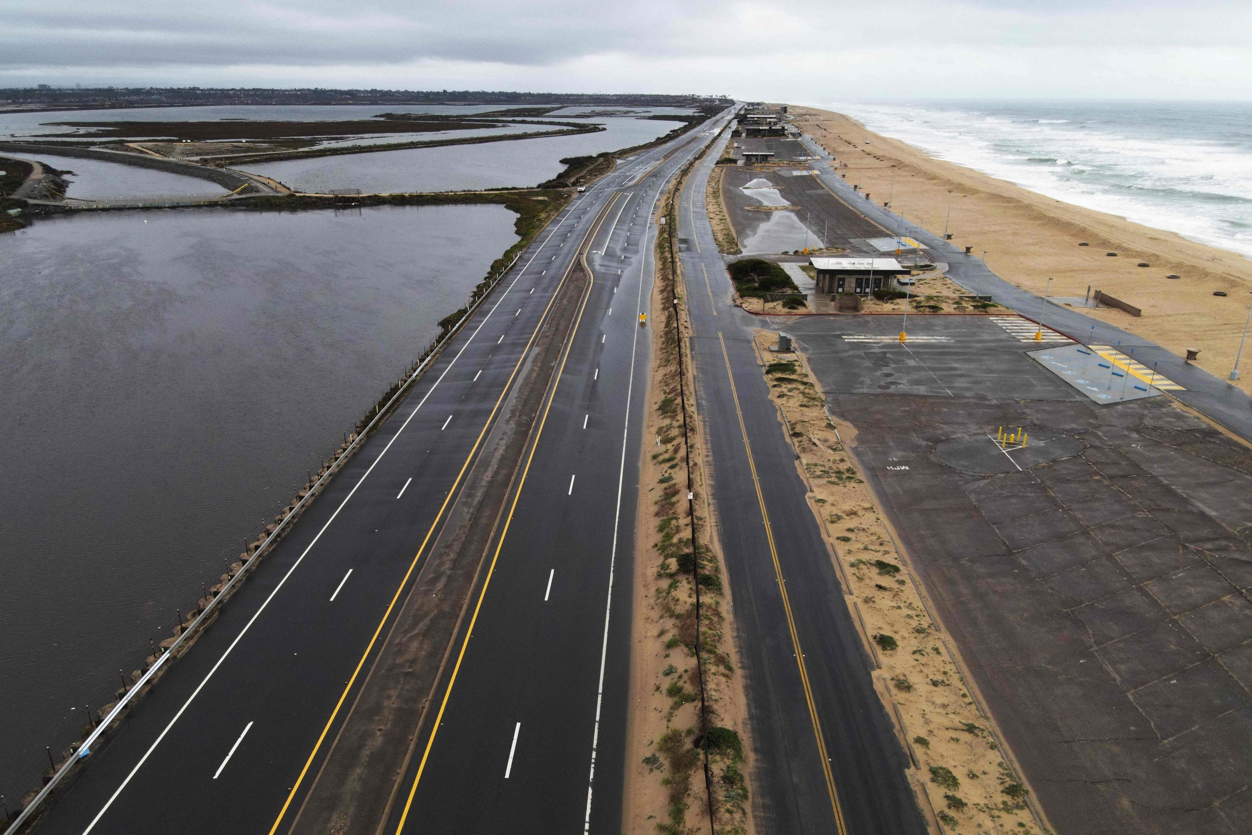 Dieses am 1. Februar 2024 aufgenommene Luftbild zeigt einen Abschnitt des Pacific Coastal Highway, der während eines Regensturms in Bolsa Chica in der Nähe von Huntington Beach, Kalifornien, wegen Überschwemmungen gesperrt war. 