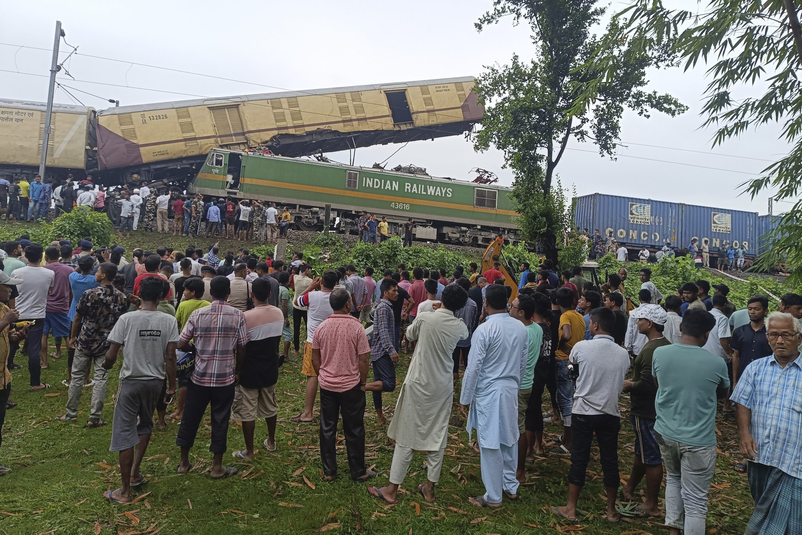 Zuschauer beobachten die Rettungsarbeiten, nachdem ein Güterzug in den Kanchanjunga Express, einen Personenzug, nahe der Station New Jalpaiguri im Bundesstaat Westbengalen, Indien, am Montag, 17. Juni 2024, gerammt hat.
