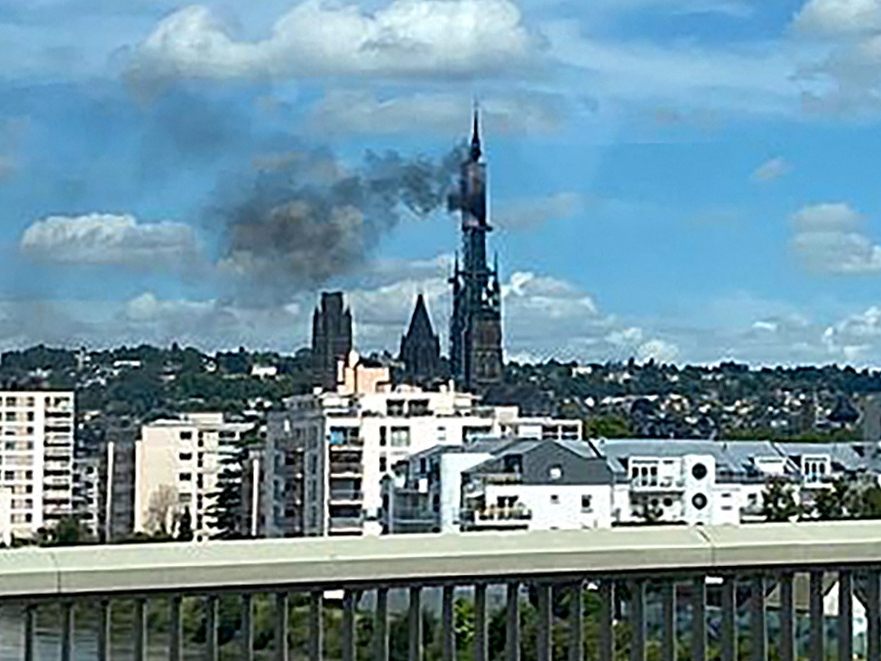 Turmspitze der Kathedrale von Rouen in Flammen.