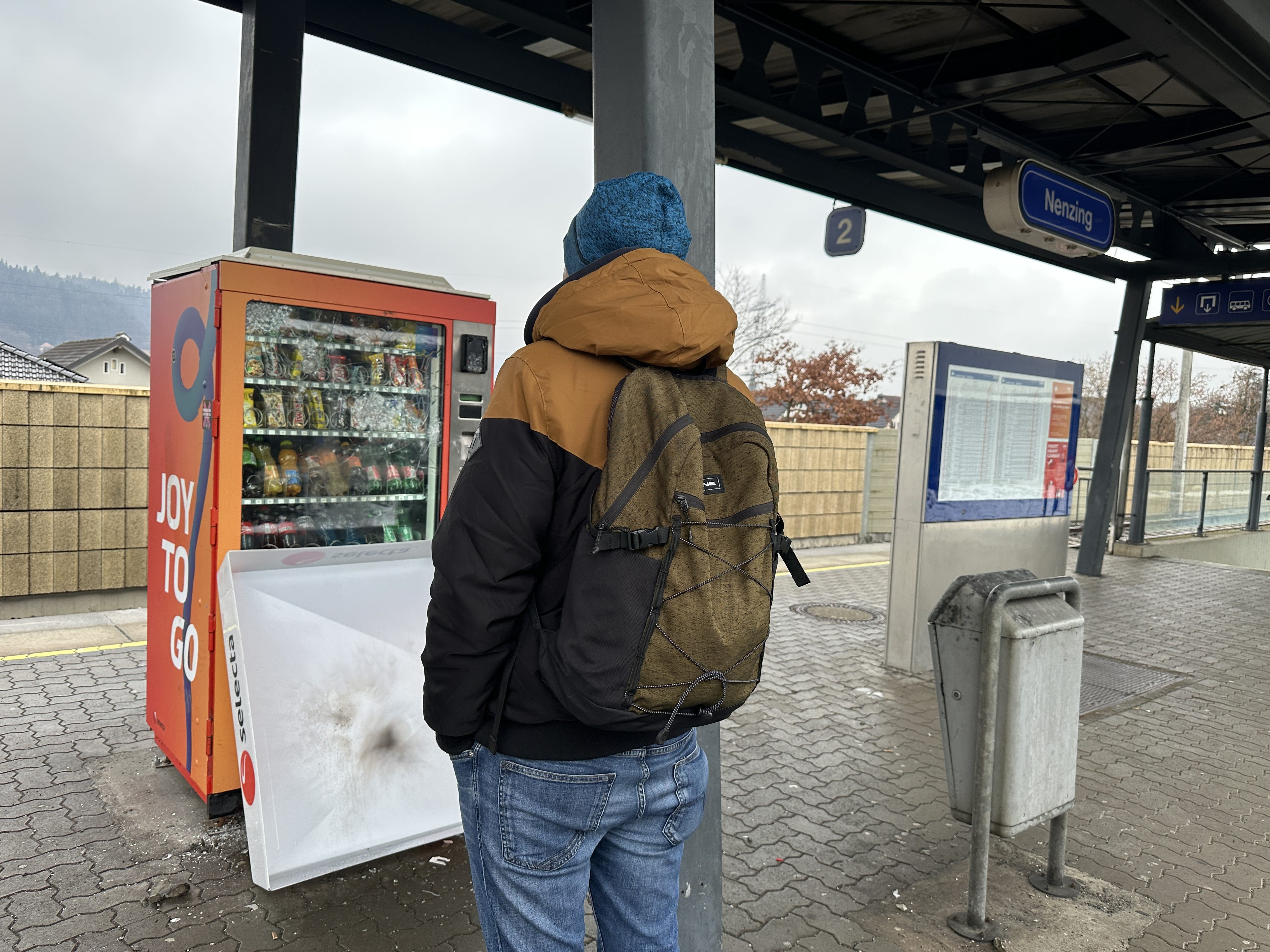Ein Nenzinger betrachtet kopfschüttelnd den beschädigten Automaten.