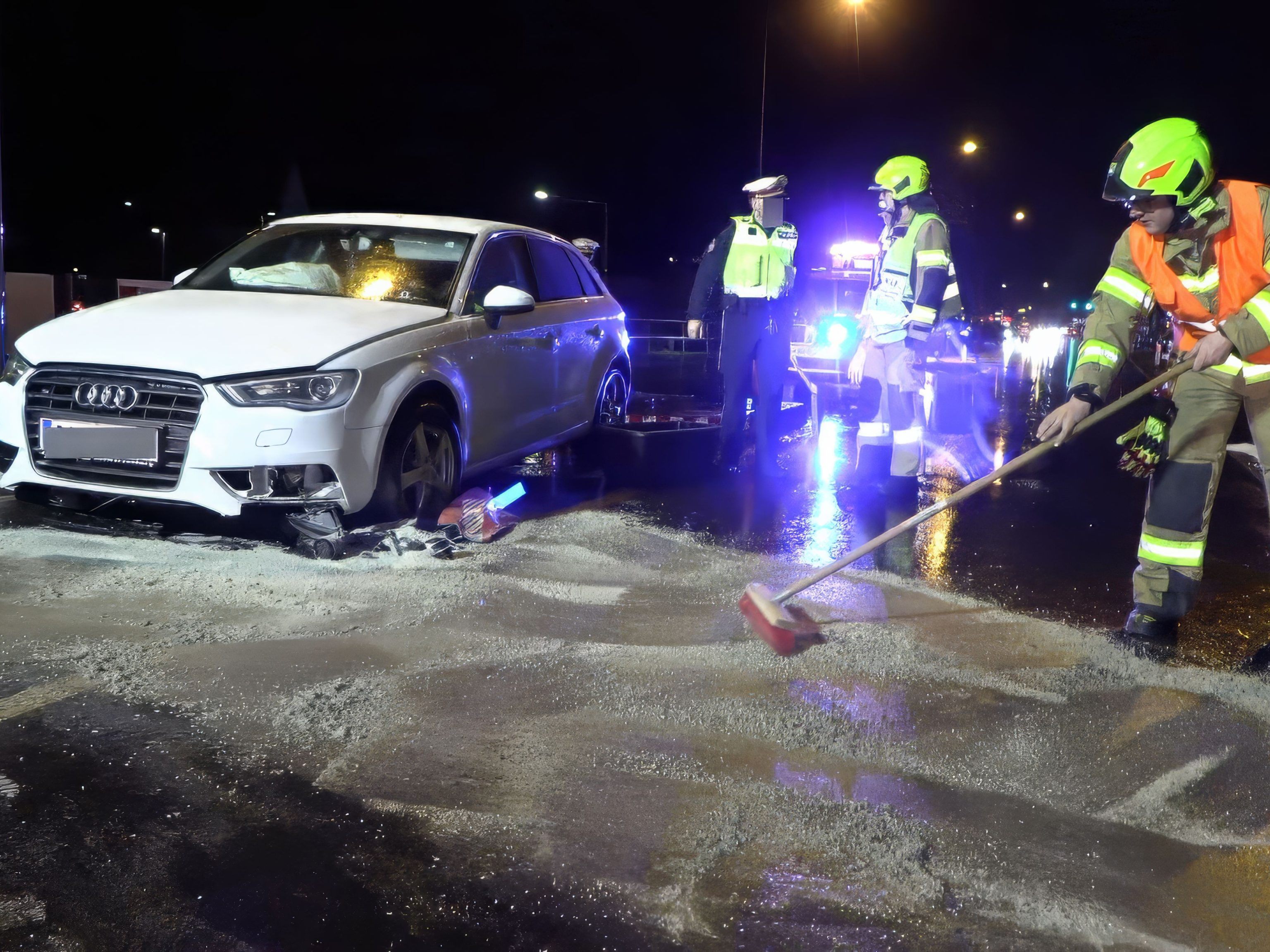 Einsatzkräfte der Feuerwehr binden auslaufende Betriebsstoffe.