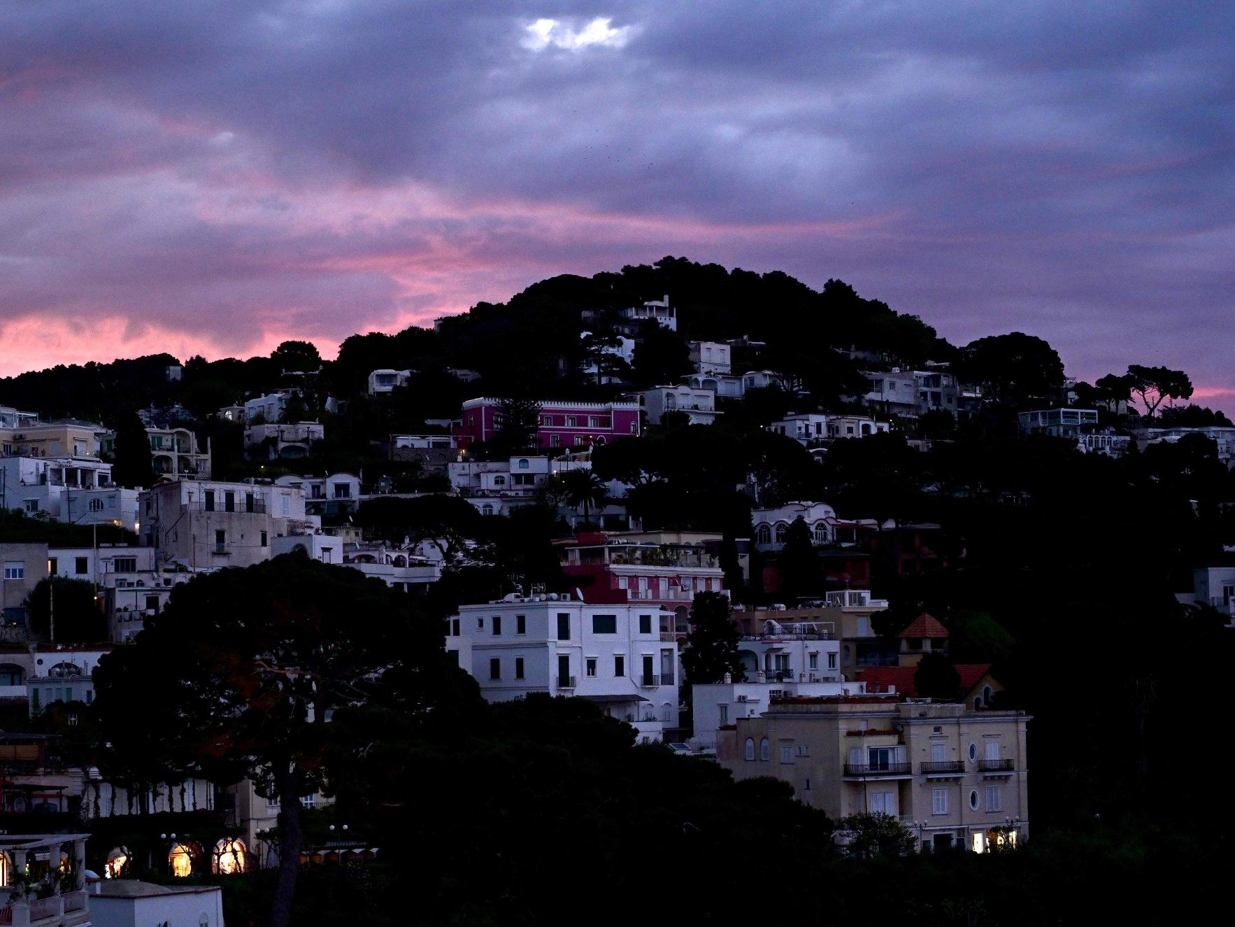 Der Himmel über der kleinen Insel Capri färbt sich bei Sonnenaufgang rosa.
