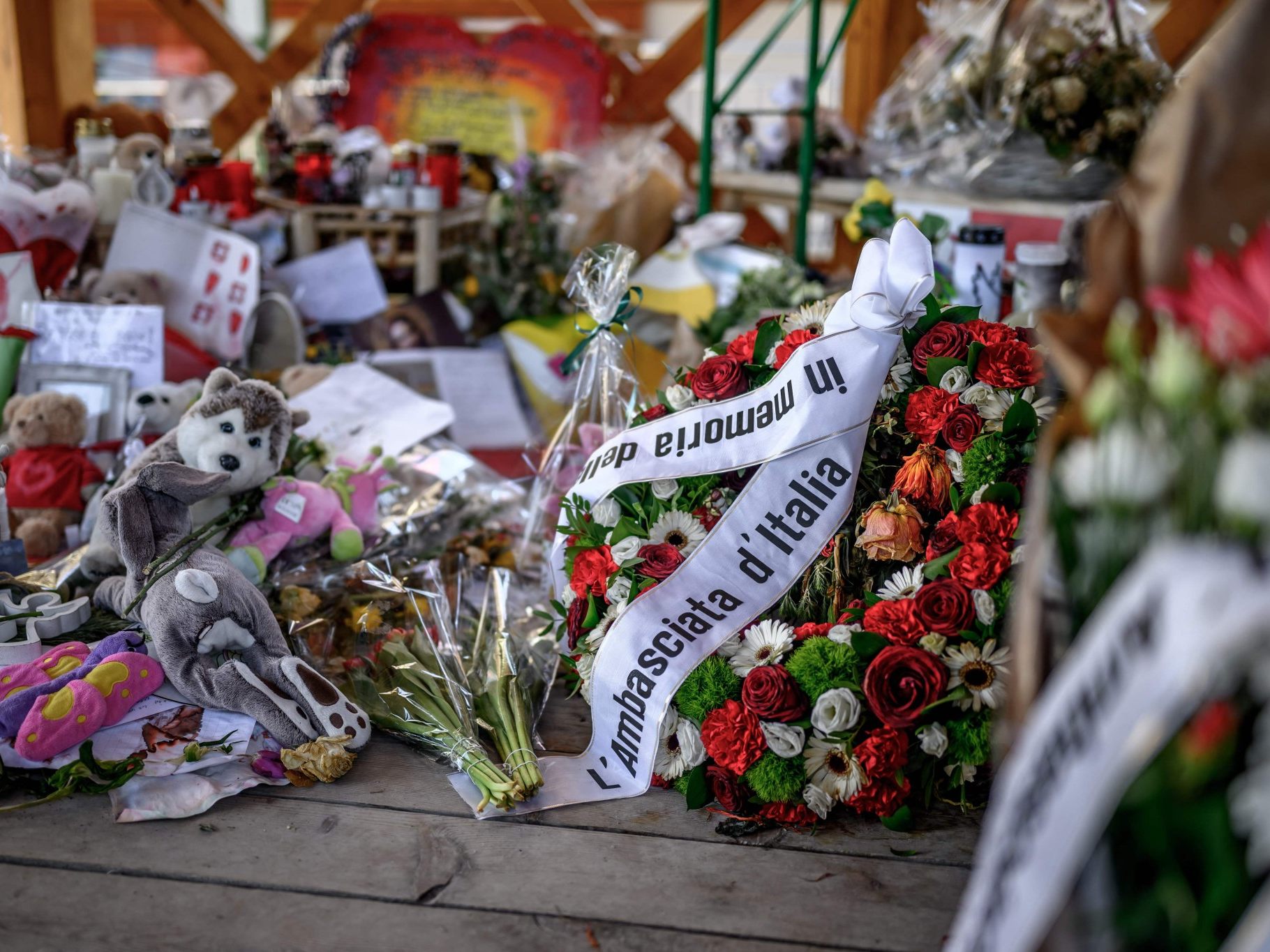 Blumen und Kerzen an der Gedenkstätte in Crans-Montana: Ein Kranz der italienischen Botschaft erinnert Monate nach dem verheerenden Brand im Club „Le Constellation“ an die 41 Todesopfer.