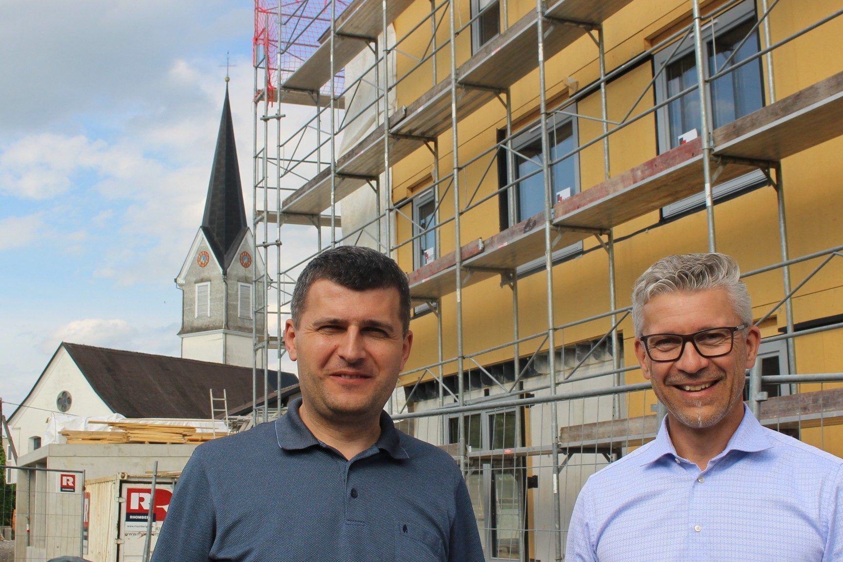 Im Hohenweiler Zentrum entsteht derzeit in Rufweite zur Pfarrkiche eine Wohnanlage mit 30 Einheiten. Wohnbauselbsthilfe-Geschäftsführer Thomas Schöpf und Projektleiter Mitar Simikic luden zum Lokalaugenschein auf die Großbaustelle. PETER STRAUSS   